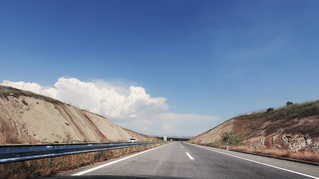 时间流逝，速度流逝，POV车辆行驶，单向公路柏油路对蓝天，汽车旅行的观点，晴天视频素材