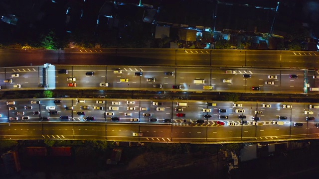 鸟瞰图繁忙的汽车与交通堵塞在高峰时间的高速公路道路街道上的桥在曼谷市中心，城市城市在晚上，泰国。交叉路口。罗摩9号收费站视频素材