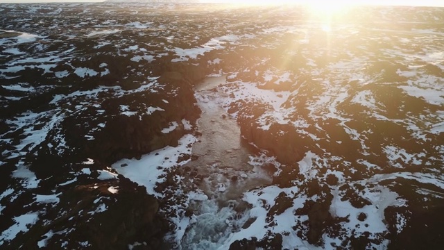 阿尔德雅福斯，瀑布和熔岩场，白雪覆盖，沐浴在日出的光芒和耀斑中视频素材