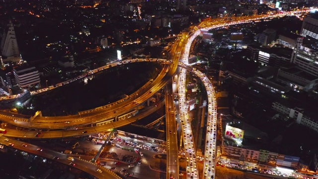 在高速公路路口行驶的汽车鸟瞰图。桥梁、街道、道路在建筑网络中的连接概念。前视图。曼谷夜市，泰国。视频素材