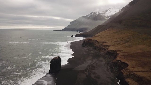 冰岛东海岸。云雾缭绕的山景，黑色的沙滩和山顶的积雪，视频素材