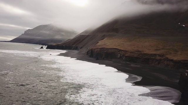 冰岛东海岸。鸟瞰图的海栈，雾山景观，黑色沙滩视频素材