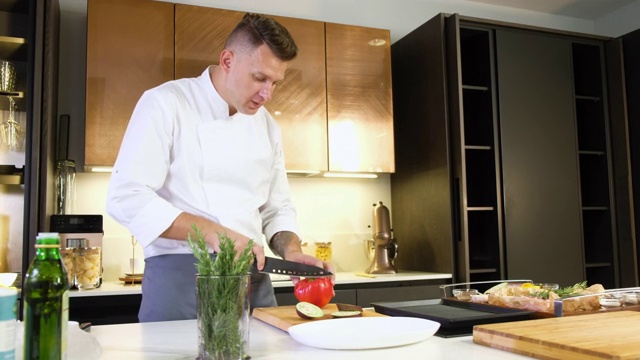 厨师在厨房的砧板上用锋利的刀切红辣椒视频素材