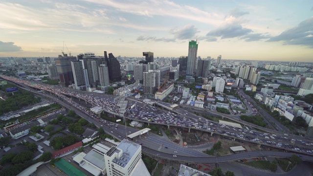 鸟瞰图繁忙的汽车与交通堵塞在高峰时间的高速公路街道上的桥在曼谷市中心，城市城市在日落时，泰国。交叉路口。罗摩9号收费站视频素材