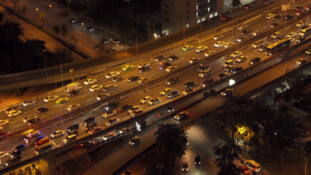 鸟瞰图繁忙的汽车与交通堵塞在高峰时间的高速公路道路街道上的桥在曼谷市中心，城市城市在晚上，泰国。交叉路口。罗摩9号收费站视频素材