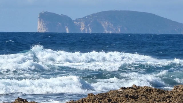 波涛汹涌的大海，卡波·卡西亚是背景。意大利撒丁岛视频素材