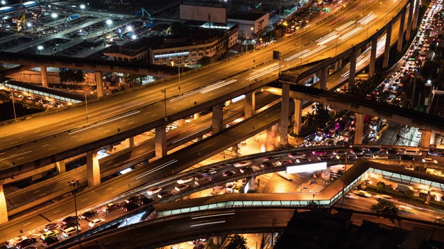 延时汽车交通运输在高速公路、公路交叉口、空铁铁路，与施工现场在夜间。城市交通生活方式，亚洲城市生活。高角度的城市景观视频素材