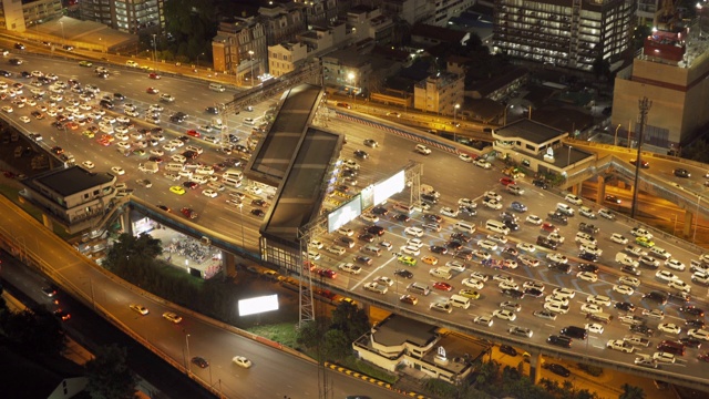 鸟瞰图繁忙的汽车与交通堵塞在高峰时间的高速公路道路街道上的桥在曼谷市中心，城市城市在晚上，泰国。交叉路口。罗摩9号收费站视频素材