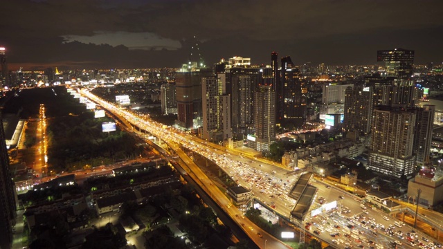 鸟瞰图繁忙的汽车与交通堵塞在高峰时间的高速公路道路街道上的桥在曼谷市中心，城市城市在晚上，泰国。交叉路口。罗摩9号收费站视频素材