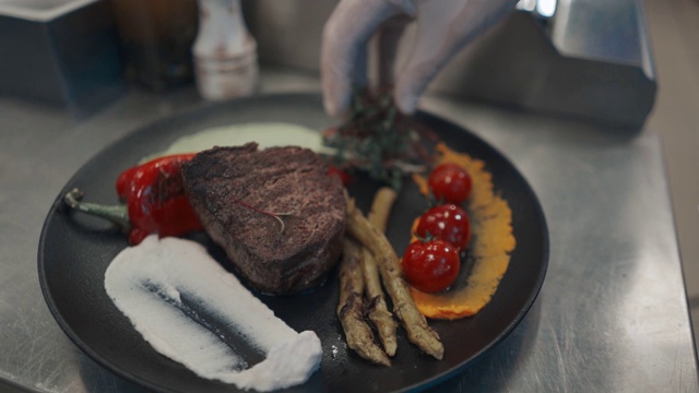 厨师烹饪肉类在商业厨房。厨师为餐厅客人烹饪生牛排的肖像。视频购买