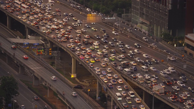 鸟瞰图繁忙的汽车与交通堵塞在高峰时间的高速公路道路街道上的桥在曼谷市中心，城市城市在晚上，泰国。交叉路口。罗摩9号收费站视频素材