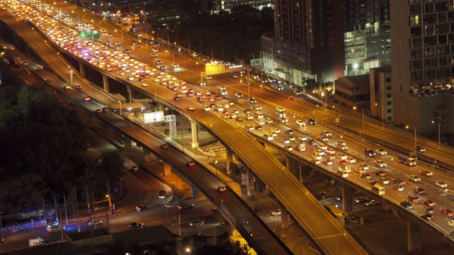 鸟瞰图繁忙的汽车与交通堵塞在高峰时间的高速公路道路街道上的桥在曼谷市中心，城市城市在晚上，泰国。交叉路口。罗摩9号收费站视频素材