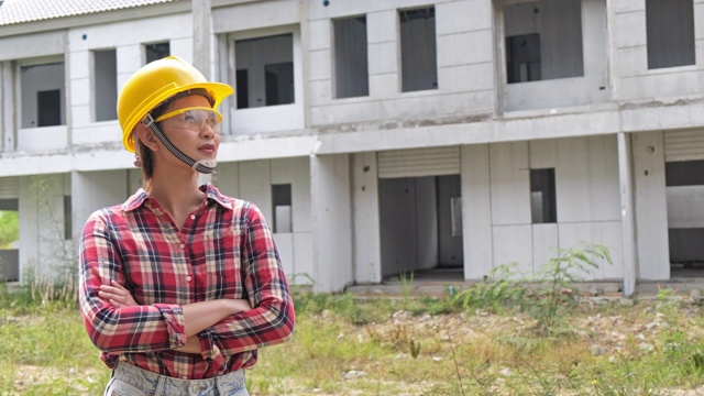 肖像妇女年轻亚洲工头工程家检查房屋房屋交叉双臂寻找施工检查房屋房屋现场客户与新常态冠状病毒covid-19视频素材