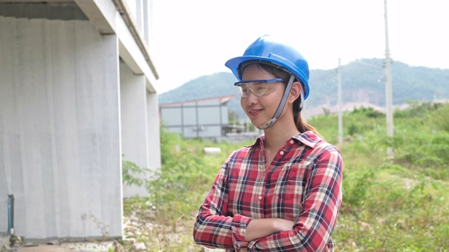 肖像妇女年轻亚洲工头工程家检查房屋房屋交叉双臂寻找施工检查房屋房屋现场客户与新常态冠状病毒covid-19视频素材