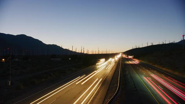 在加州棕榈泉的I-10高速公路上，风力涡轮机和交通的延时视频素材