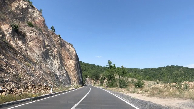 时光流逝司机POV在乡村公路上向前行驶，穿越山峦和山谷的自然风景视频素材