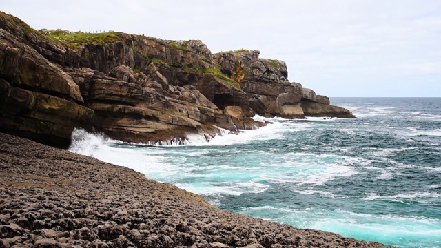 海浪拍打着海岸上的岩石悬崖的风景。视频素材