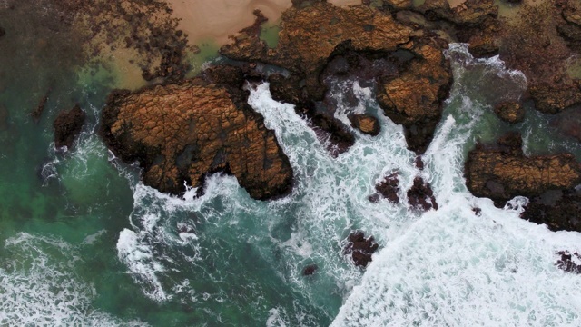 海浪撞击岸边岩石的鸟瞰图视频素材