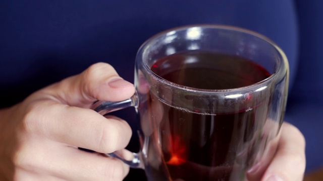 女性手捧一杯热茶，蒸汽从杯子里冒出来视频素材