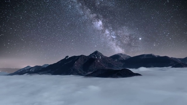 蓝色夜空与星星和银河系移动高山与雾云山谷天文时间流逝视频素材