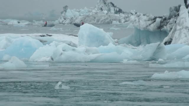 冰岛Jökulsárlón海面上冰山之间的宽阔船只视频素材