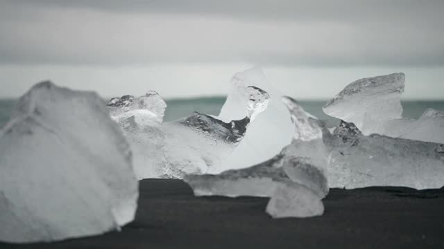 特写镜头，冰岛黑色火山海滩上的大块冰块视频素材