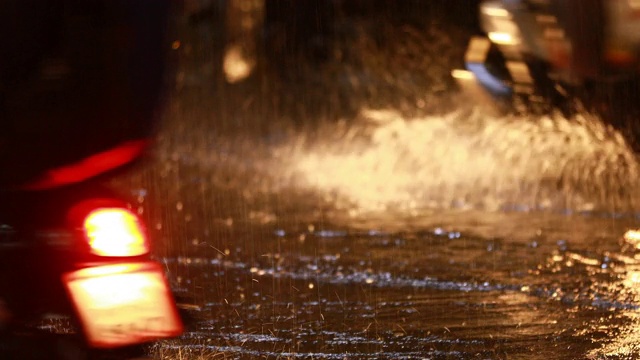 在暴雨引起的洪水中在被淹没的道路上驾驶汽车视频素材