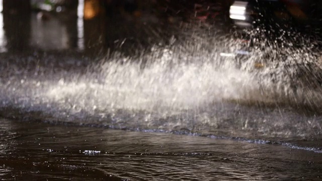 在暴雨引起的洪水中在被淹没的道路上驾驶汽车视频素材