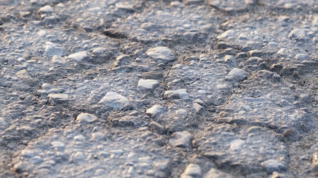 道路上混凝土沥青裂缝的宏观特写。视频素材