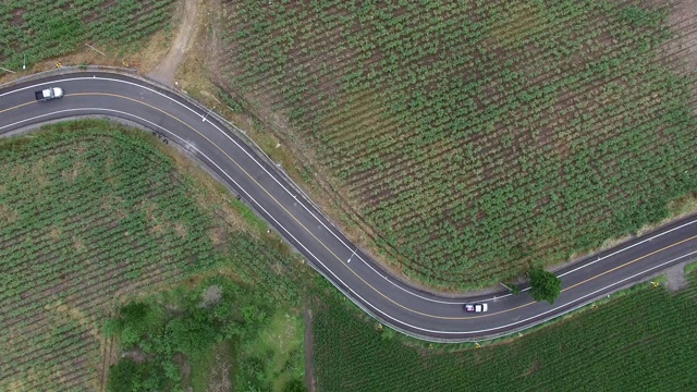 鸟瞰图道路弯道施工。鸟瞰乡村景观，蜿蜒的道路贯穿其中。视频素材