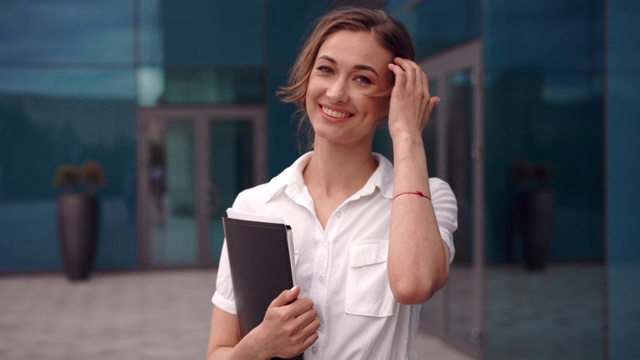 女商人成功的女商人站在户外公司大楼的外部。兴奋的白人自信职业女性中年视频素材