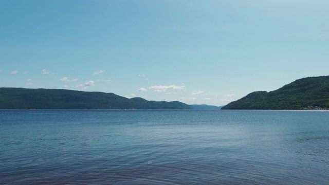 在阳光明媚的日子里，从岸边看到峡湾的风景，山上有树视频素材