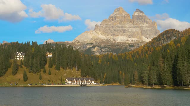 风景优美的山峰高耸在五颜六色的森林和宁静的湖滨酒店视频素材