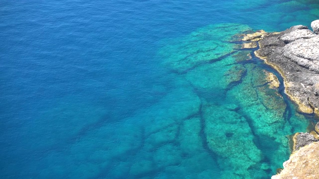 岩石海岸和绿松石清澈的大海。视频素材