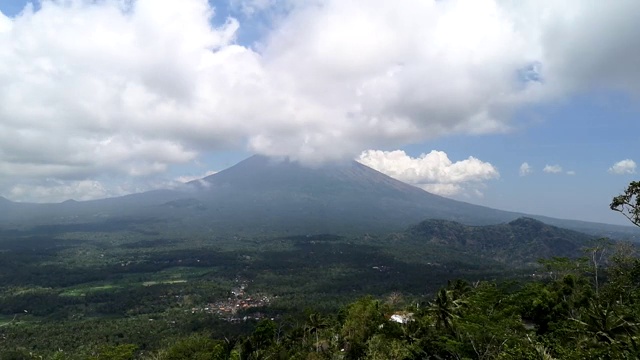 印尼巴厘岛阿贡火山云中鸟瞰图。火山附近的奇妙景观，在亚洲的绿色山谷移动云的阴影。视频素材