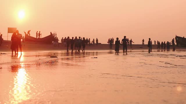 夕阳下的圣马丁岛。海浪和人们在海滩上的活动。视频素材