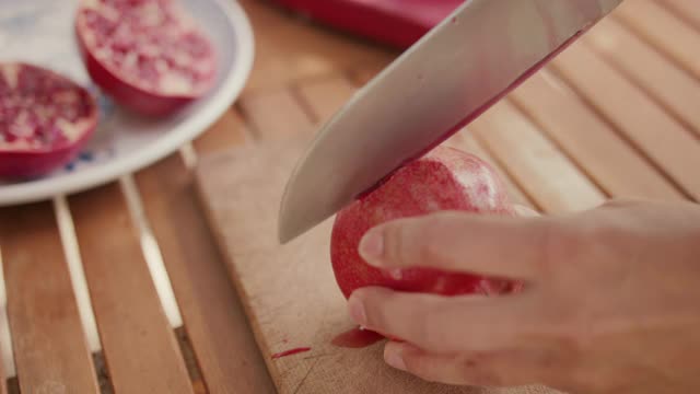 女人把石榴切成两半视频素材