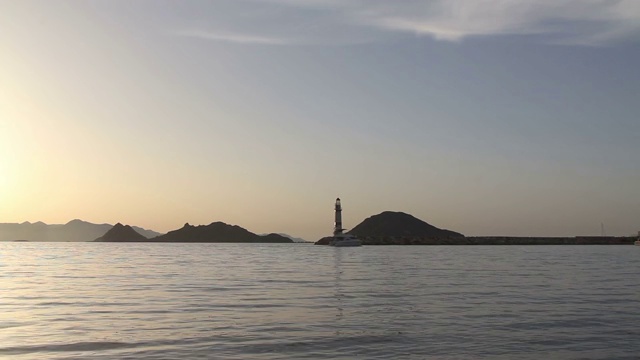 在夕阳海景。海岸上的灯塔。海边小镇Turgutreis和壮观的日落视频素材