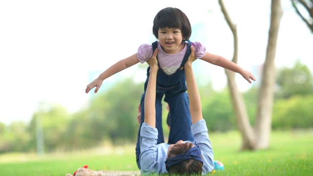 妈妈和女儿在院子里一起玩，胳膊伸着视频素材