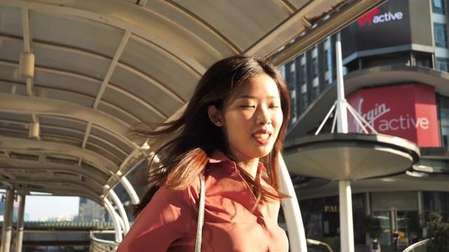 女商人在街上奔跑。女人在户外用智能手表看时间视频素材