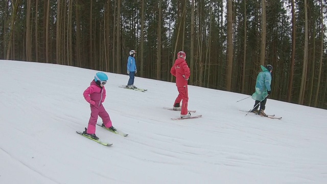 这孩子跟着教练学滑雪。视频素材