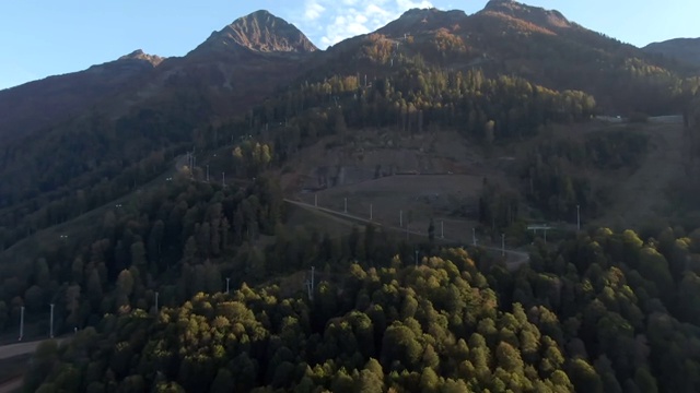 鸟瞰图飞行在秋天的美丽的森林在山区。日落时五颜六色的群山全景。在山里旅游和娱乐视频素材