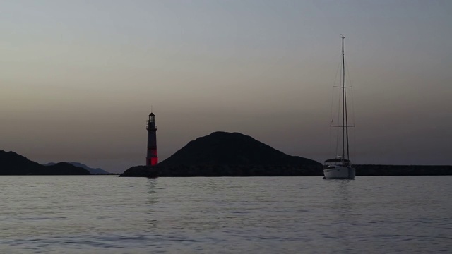 在夕阳海景。海岸上的灯塔。海边小镇Turgutreis和壮观的日落视频素材