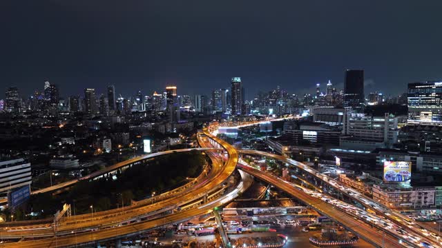 在高速公路路口行驶的汽车鸟瞰图的时间流逝。桥梁、街道、道路在建筑网络中的连接概念。前视图。曼谷夜市，泰国。视频素材