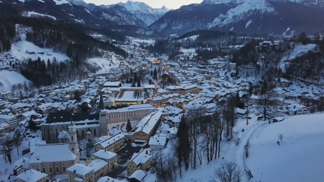 德国巴伐利亚的贝希特斯加登老城区被冬季积雪覆盖的夜景鸟瞰图。视频素材