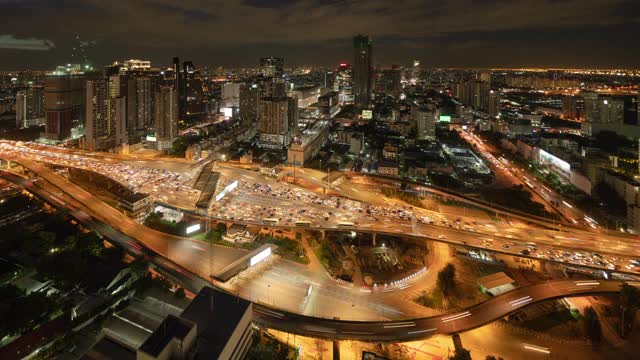 在曼谷市中心，城市城市，泰国夜间的高速公路道路上的桥上，繁忙的汽车与交通堵塞在高峰时间的鸟瞰图。交叉路口。罗摩9号收费站视频素材