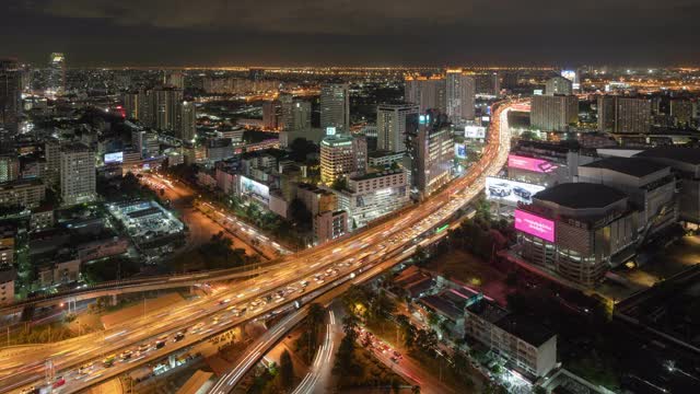 在曼谷市中心，城市城市，泰国夜间的高速公路道路上的桥上，繁忙的汽车与交通堵塞在高峰时间的鸟瞰图。交叉路口。罗摩9号收费站视频素材