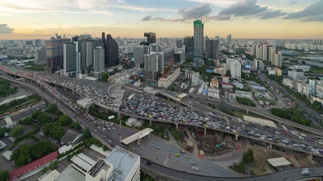 在曼谷市中心，在亚洲，泰国的城市城市，日落时分，在高速公路道路上的桥上，繁忙的汽车与交通堵塞的鸟瞰图的时间流逝。交叉路口。收费站视频素材