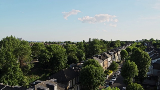 住宅梯田住房的观点在伦敦北部中部，英国与郁郁葱葱的树木在周围-高角度平移镜头视频素材