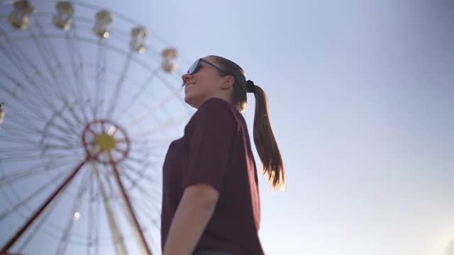 通往自由，幸福和有趣的生活方式的旅程。时髦女人环顾四周。用摩天轮探索城市。视频下载